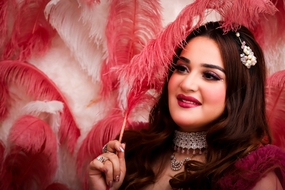 手持红色羽毛的印度微胖美女图片